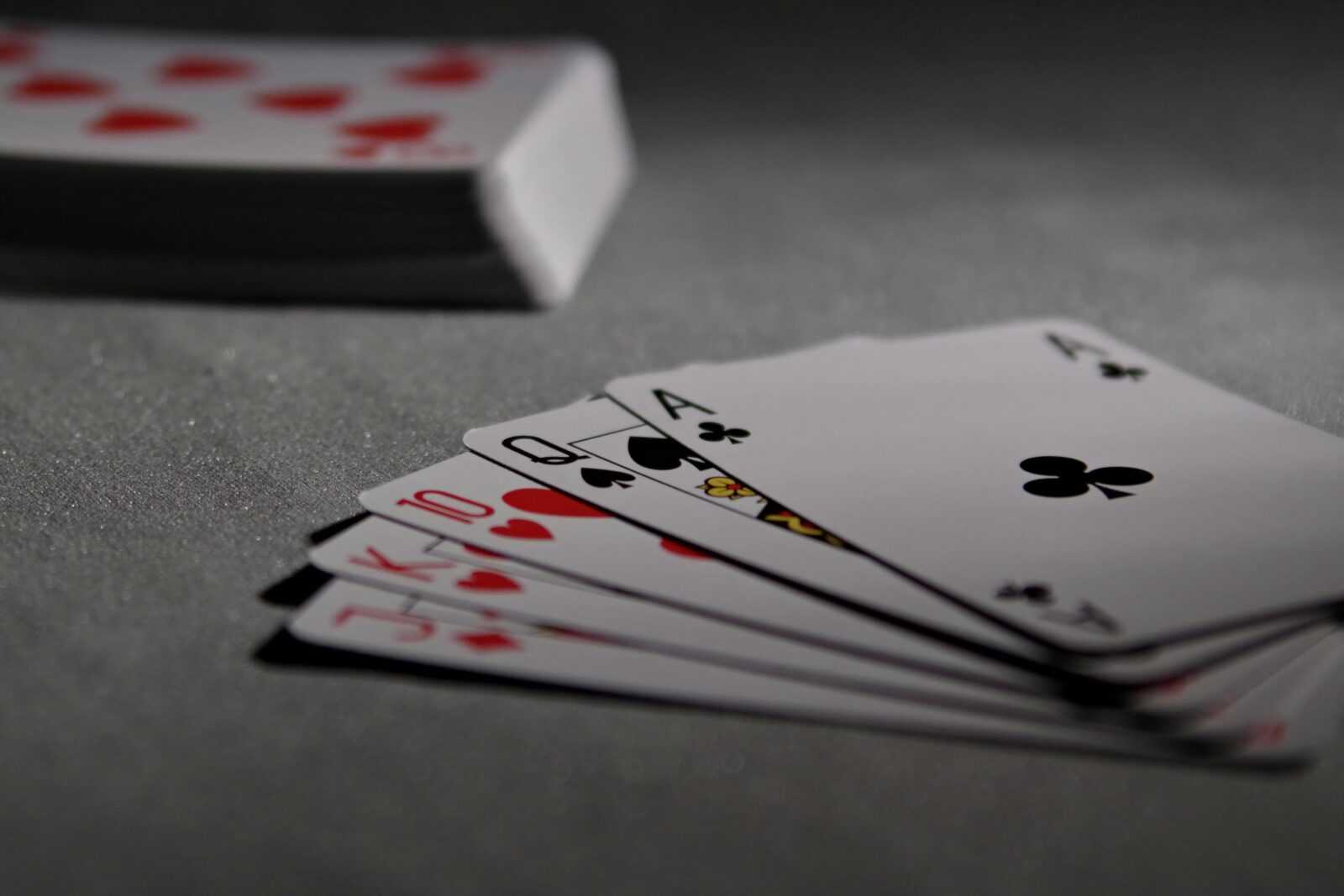 Detailed view of playing cards displaying a winning poker hand in a dimly lit scene.