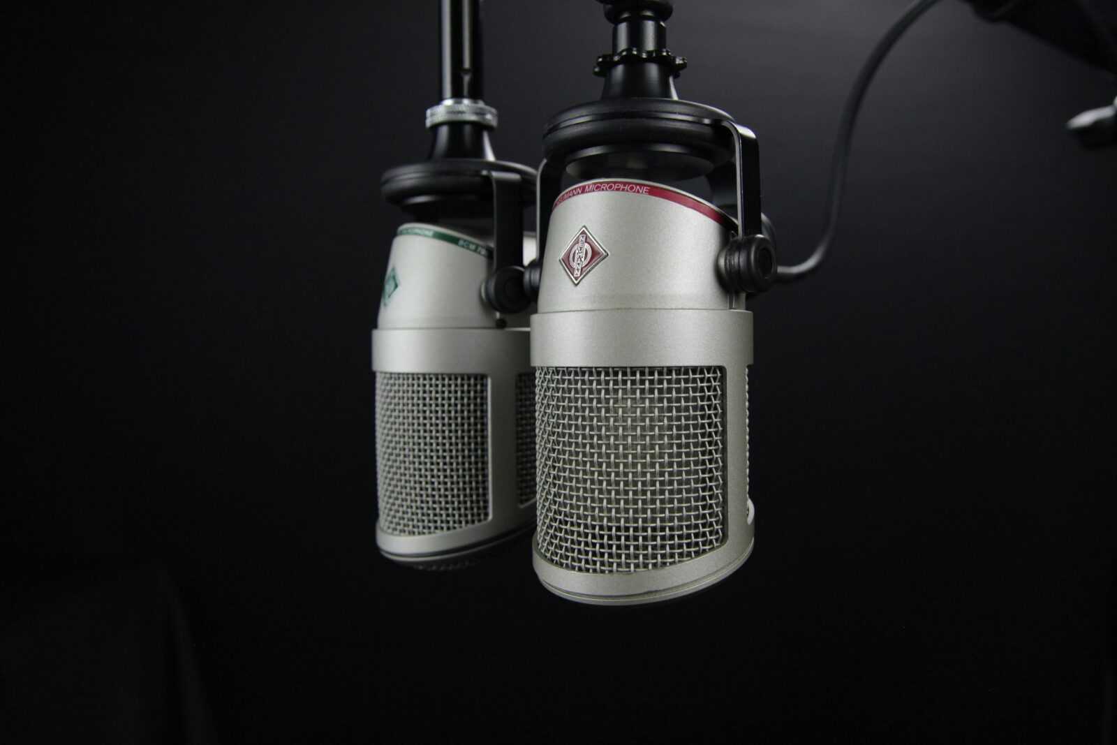 Close-up of two professional microphones in a recording studio, ideal for podcasts and music production.